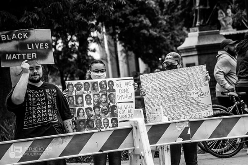 Two protesters hold signs at the Black Lives Matter protest in Mansfield in May 2020