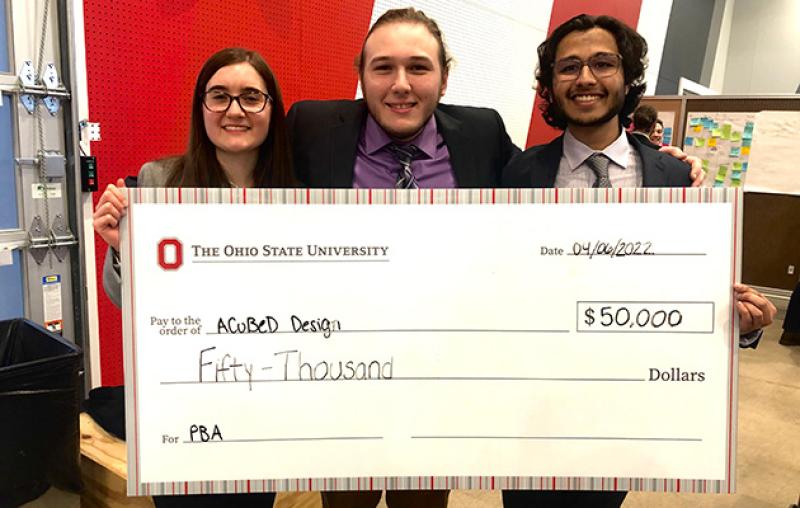 A Cubed Design team with a giant check A Cubed Design team with a giant check