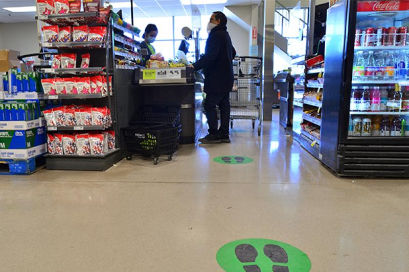 Customer wearing mask and social distancing in check-out line of grocery story Customer wearing mask and social distancing in check-out line of grocery story