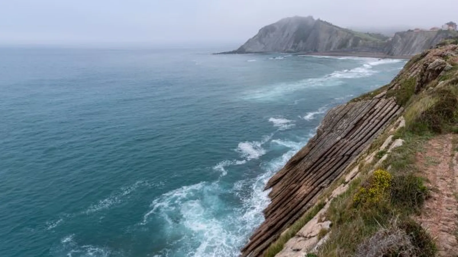 WAVES AGAINST A CLIFF FACE