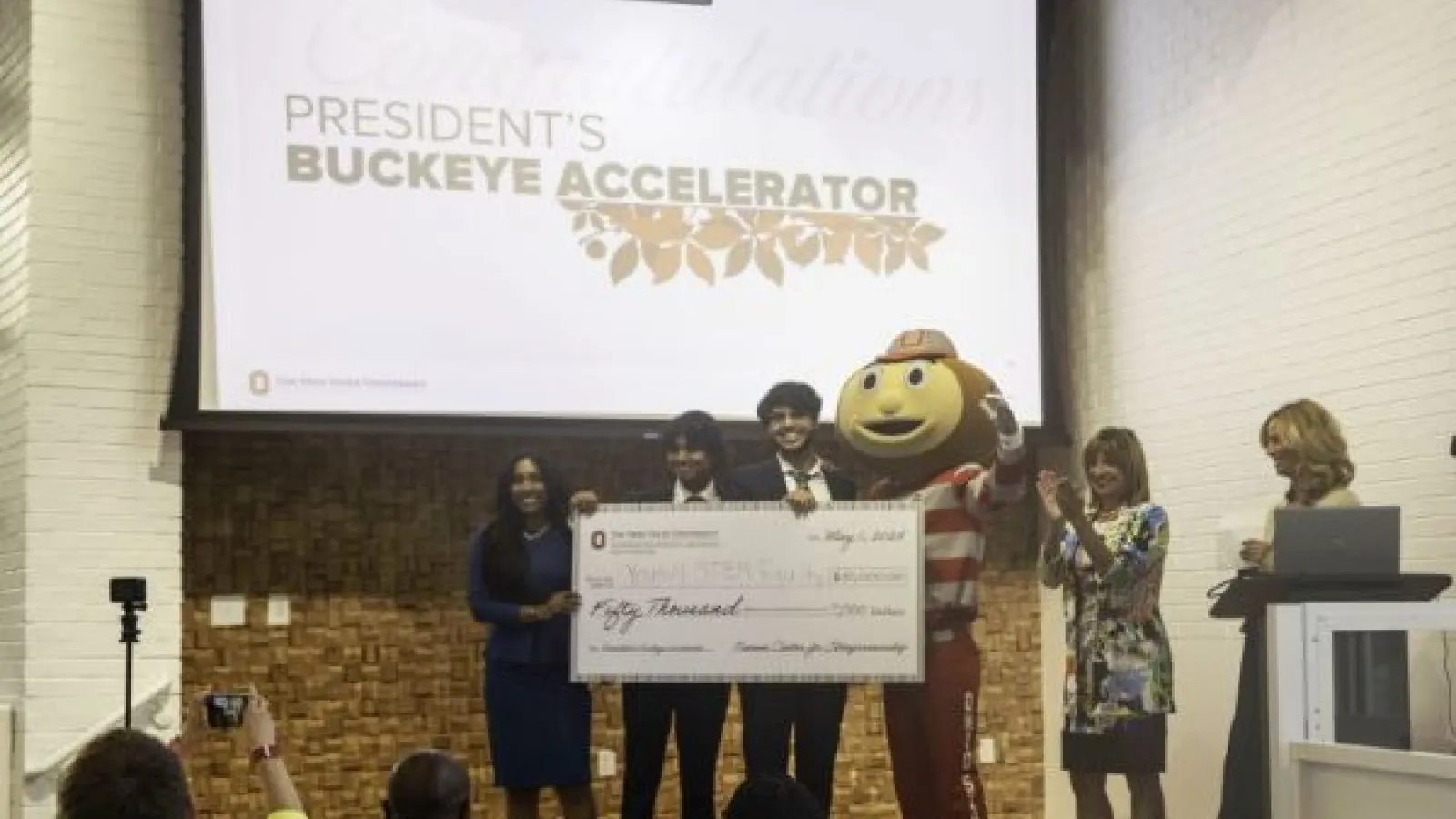 the Youth for STEM Equity team receives a large award check