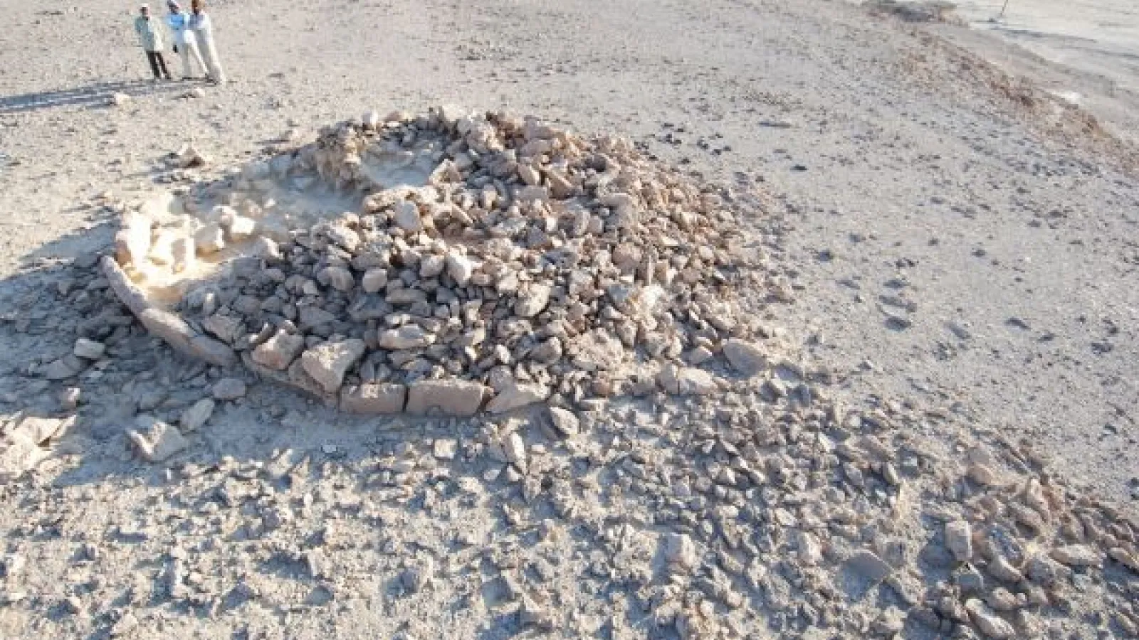 Researchers look over the remains of a platform monument