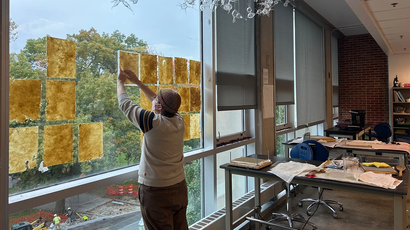 A student drys paper on a window