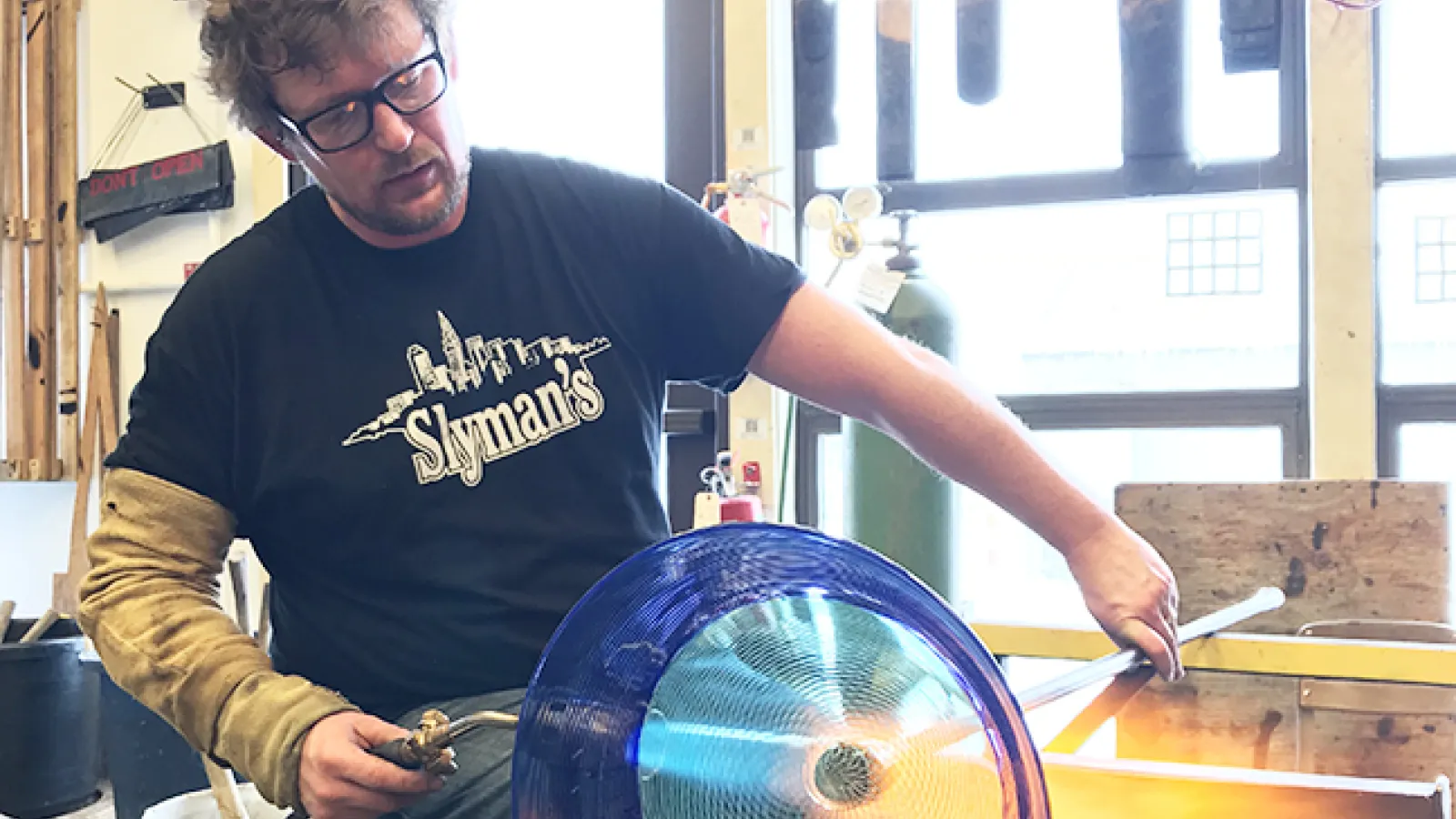 Jonathan Capps, a glassmaker in the Department of Art, uses a blowtorch on a piece of glass art he's making. Capps will spend nine months in Finland for a Fulbright-funded research project.