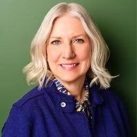 Linda Thomas Brooks smiles on a green background