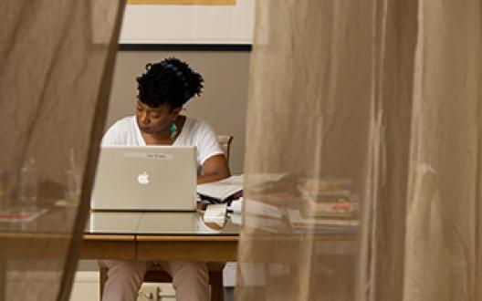 Yona Harvey writing at a desk