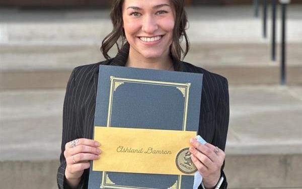 Ashland Damron holding an award