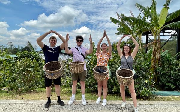 Students making O-H-I-O in front of palm trees