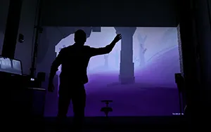 Someone in front of a big screen demonstrating virtual reality at ACCAD Open House