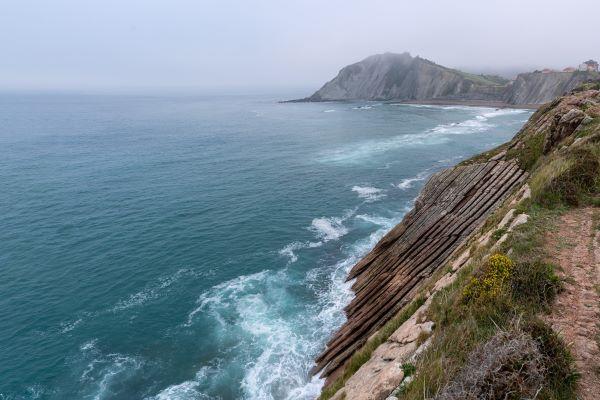 WAVES AGAINST A CLIFF FACE
