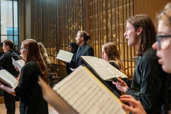 a choral group holding sheet music