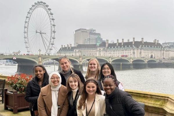 students pose in front of the London Eye