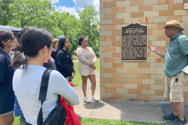 students look at a historical plaque
