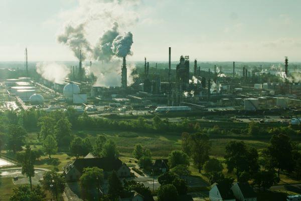 an oil refinery in the background of a city neighborhood