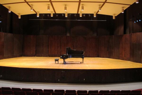 a piano sits on an empty stage