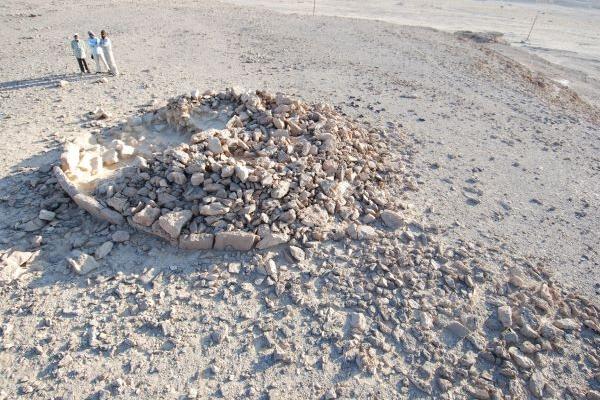 Researchers look over the remains of a platform monument