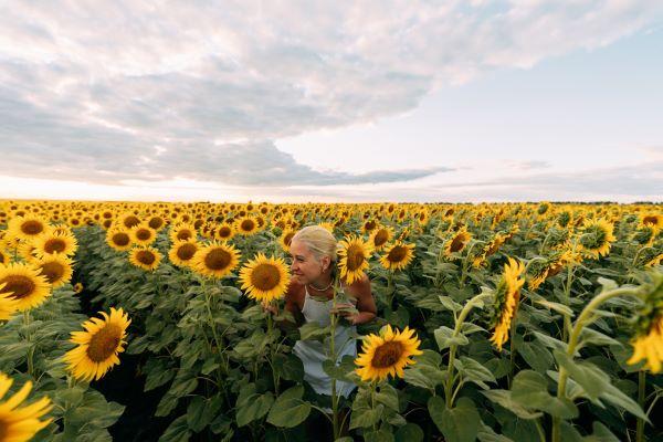 a woman standing in a field of sunflowers