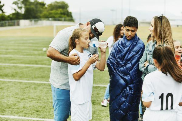 parents and their kids at a soccer field