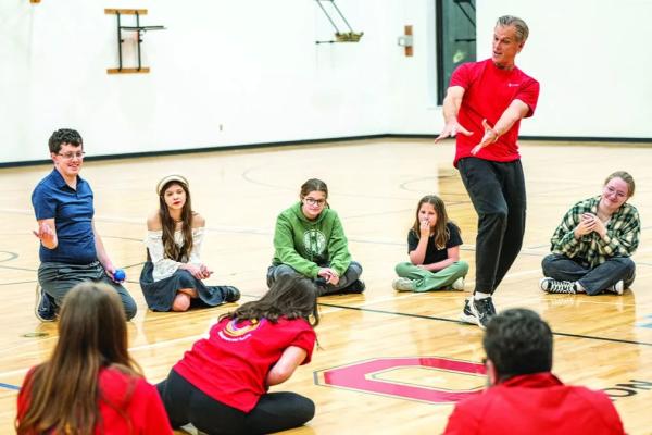 Kevin McClatchy works with students as part of a movement class