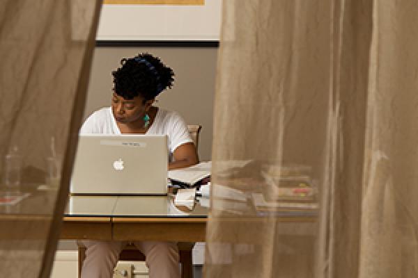 Yona Harvey writing at a desk