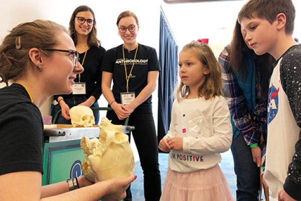 Members of APOP speak with children at COSI