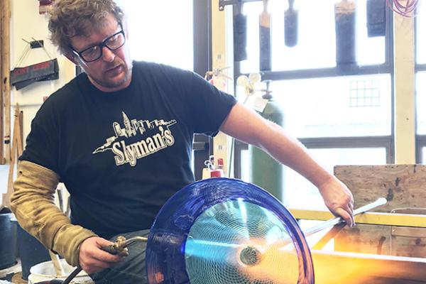 Jonathan Capps, a glassmaker in the Department of Art, uses a blowtorch on a piece of glass art he's making. Capps will spend nine months in Finland for a Fulbright-funded research project. Jonathan Capps, a glassmaker in the Department of Art, uses a blowtorch on a piece of glass art he's making. Capps will spend nine months in Finland for a Fulbright-funded research project.