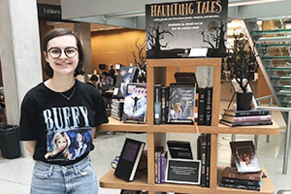 English major Rachel Stewart stands next to the display of horror literature in Thompson Library. English major Rachel Stewart stands next to the display of horror literature in Thompson Library.