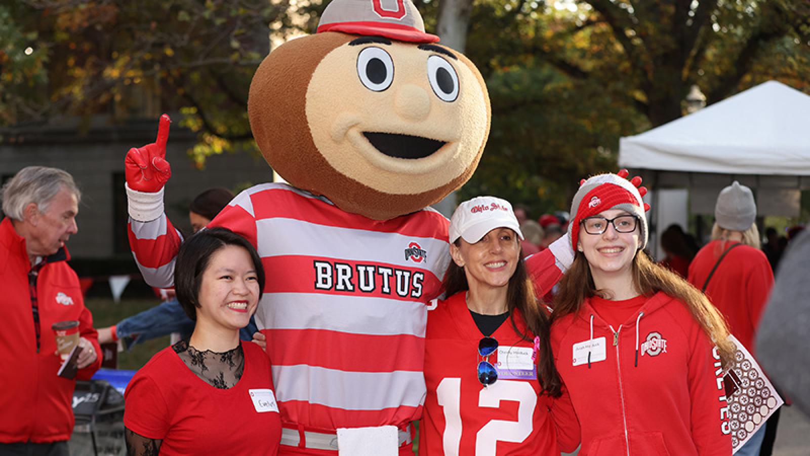 Three alumni board members with Brutus Buckeye