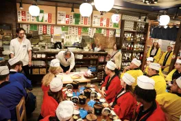 Students watch as the Sushi Master slices up the Japanese yellowtail during their authentic sushi making experience