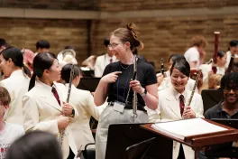 Flutist, Katie Sharp, speaks with a fellow flutist of the Osaka Gyosei Wind Orchestra